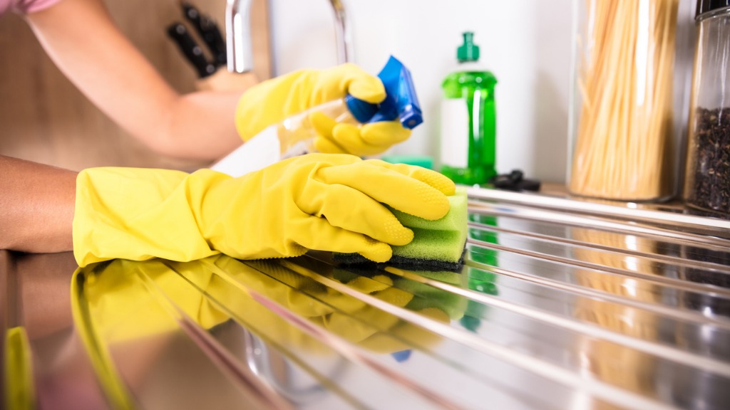 Persons hand cleaning stainless steel sink picture id917892668